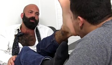 Bald bearded hunk foot worshipped and licked by young lad